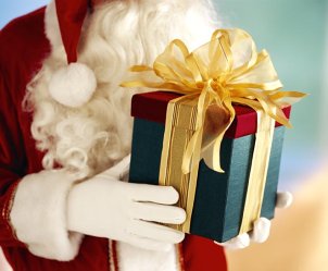 Santa holding a beautifully wrapped Christmas gift
