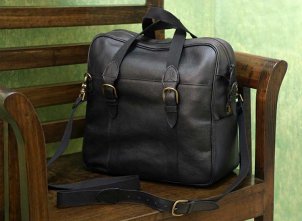 A handsome black leather business case sitting on a chair