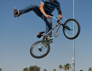 Guy doing tricks on a cool, black BMX bike