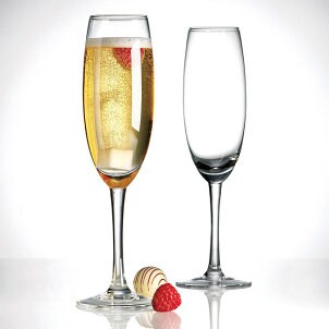 Champagne-filled toasting flute stands next to empty champagne flute