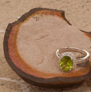 A green cubic zirconia ring on the beach