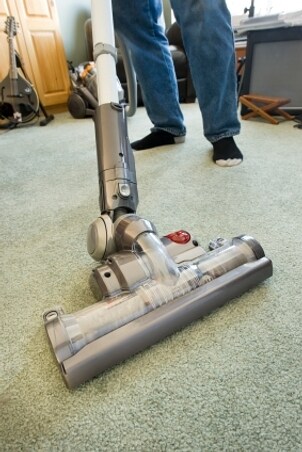 Man using a canister vacuum cleaner