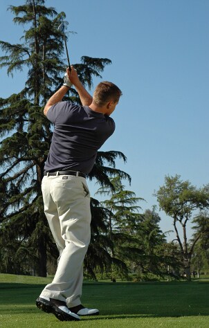 Man taking a swing with a golf iron