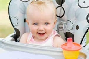 Cute baby sitting a high chair and smiling