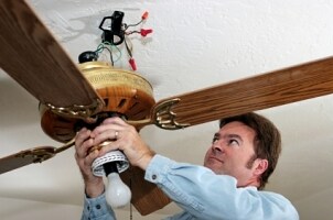 Electrician installing a ceiling fan