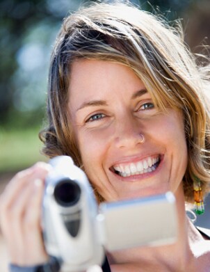 Woman filming with her camcorder in a park