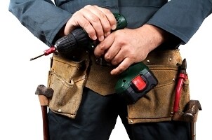 Man with a toolbelt and a cordless drill