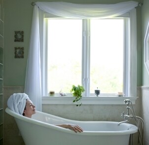 Woman relaxing in a claw foot tub