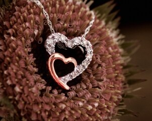 Gold and silver diamond heart pendant on a flower