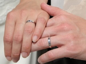 A couple wearing platinum wedding rings