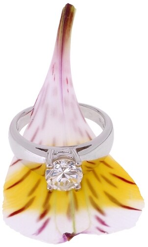 Stunning solitaire diamond engagement ring on a pink and yellow flower petal