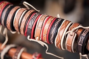 A stack of men's leather jewelry for sale