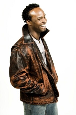 Gorgeous man wearing a brown leather jacket and a leather necklace