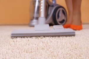 Woman using a canister vacuum