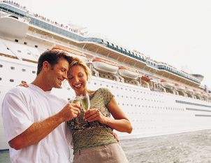 Couple toasting outside their cruise ship