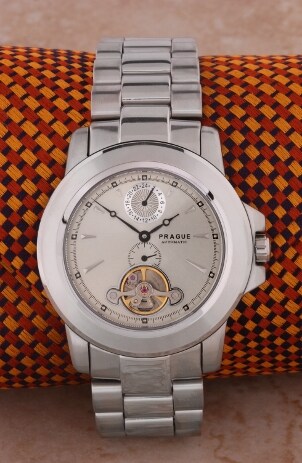 Stainless steel luxury watch wrapped around an orange, red and black checkered cloth