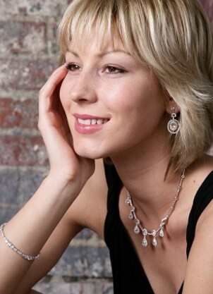 Lovely blond woman wearing a diamond necklace, a diamond bracelet, and a pair of diamond earrings