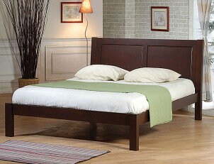 Dark wooden platform bed with white sheets and green throw blanket