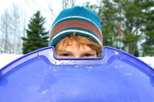 Little boy peering over his sled