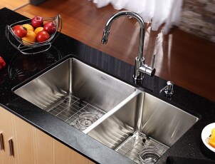 Clean stainless steel kitchen sink in a black counter