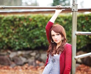 Woman wearing red cardigan near playground