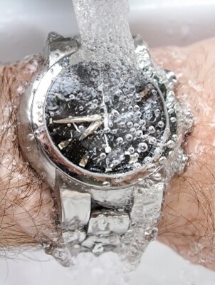 A water-resistant watch under running water