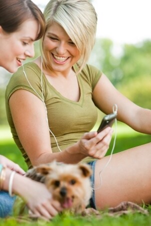 Girls sharing headphones from an MP3 player