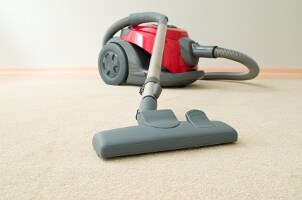 Red canister vacuum on beige carpet