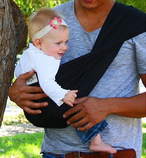 Baby girl in a baby sling carrier