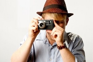 Man in a hat holding a camera