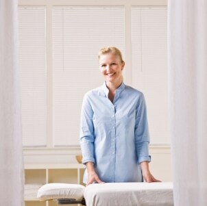 Massage therapist standing next to her massage table