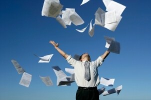 Man throwing laser printer paper into the air
