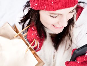 Woman in hat and gloves holding cell phone