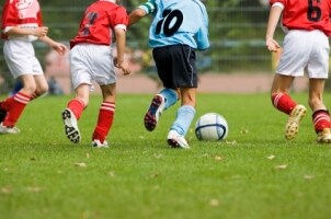 Guys playing soccer with proper soccer equipment