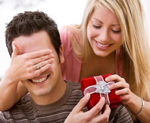 A woman giving her husband cufflinks for Valentine's Day