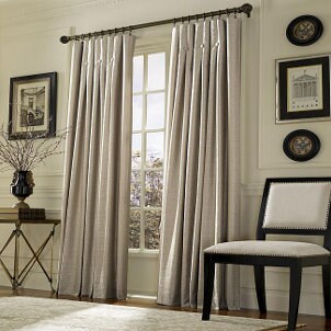 Beige drapes hang from drapery hooks in the living room
