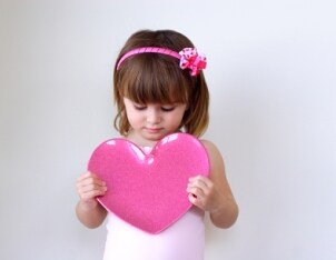 Cute little girl dressed in girls' clothes for Valentine's Day