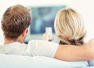 Couple watching movies online on their home theater system