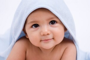Cute baby boy under a baby blanket