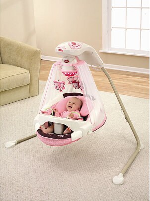 Cute baby girl in a baby swing