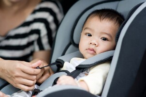 Cute baby boy sitting in a convertible car seat